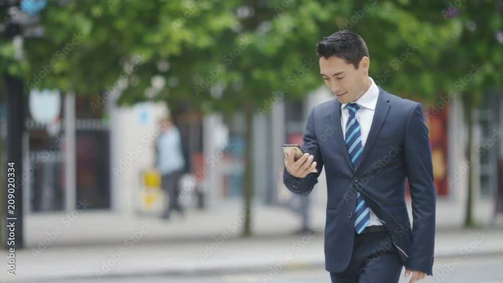 Handsome man watches something on his phone and celebrates Handsome man watches something on his phone and celebrates