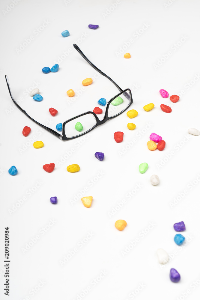 a pair of glasses between small colored stones a pair of glasses between small colored stones