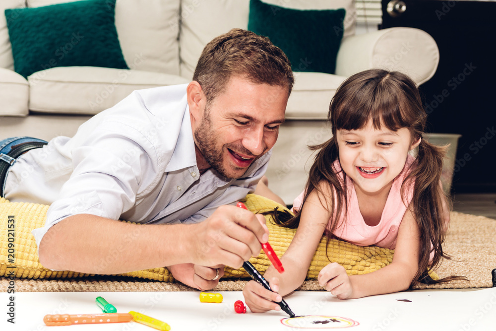 Father with little daughter having fun and do her homework at home.painting and drawing.Love of family and father day concept Father with little daughter having fun and do her homework at home.painting and drawing.Love of family and father day concept