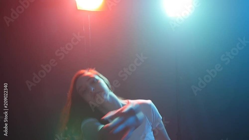 Young woman modern dancer in color light
