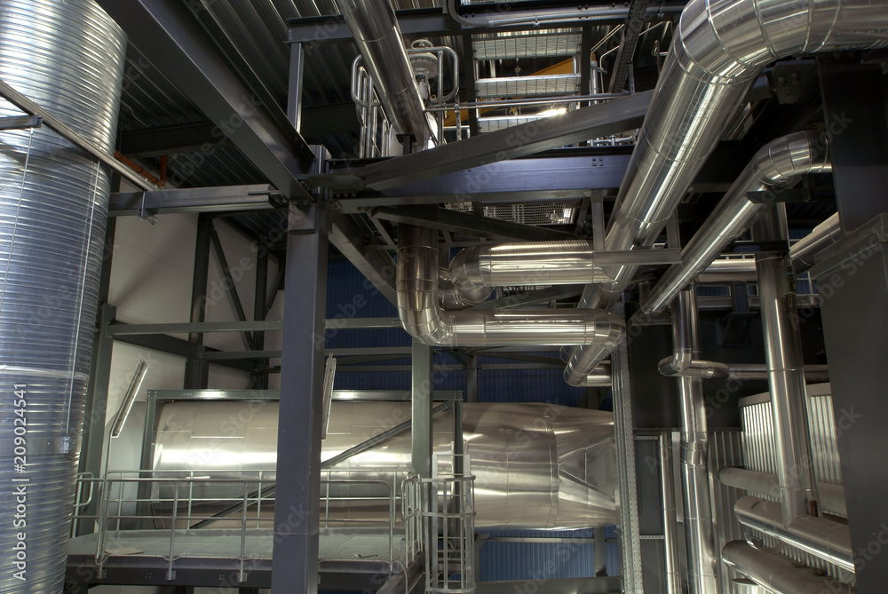 Equipment, cables and piping as found inside of a modern industrial power plant. Industrial zone, Steel pipelines, valves, cables and walkways