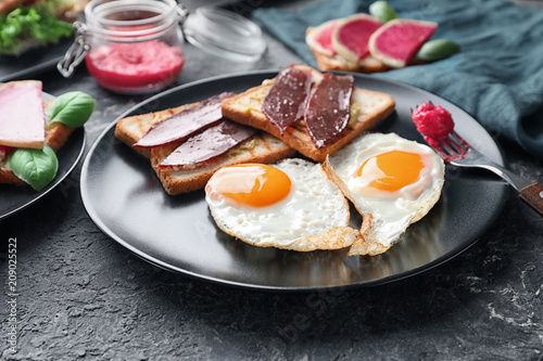 Plate with toasted bread and eggs on textured table