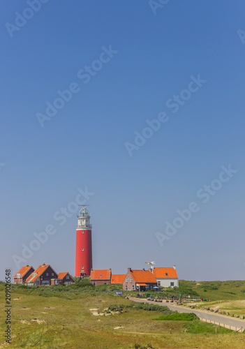Red lighthouse and houses in the dunes of Texel island, The Netherlands