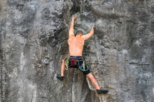 rock climber climbs on a rocky wall without insurance