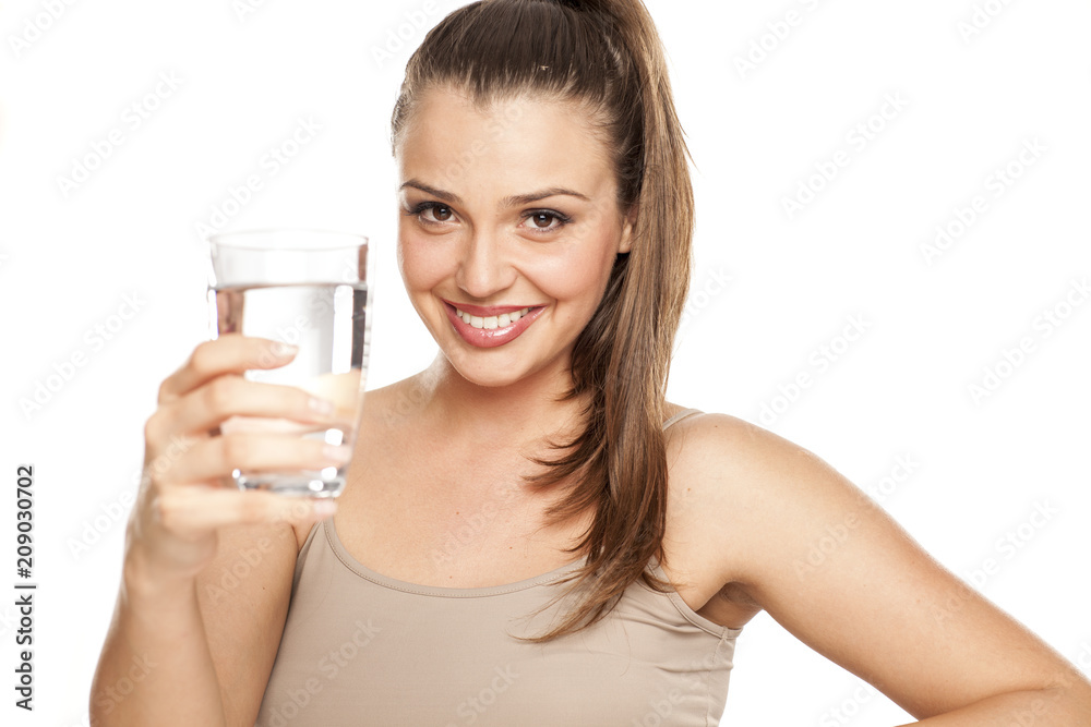 happy woman holds a glass with water on white background happy woman holds a glass with water on white background