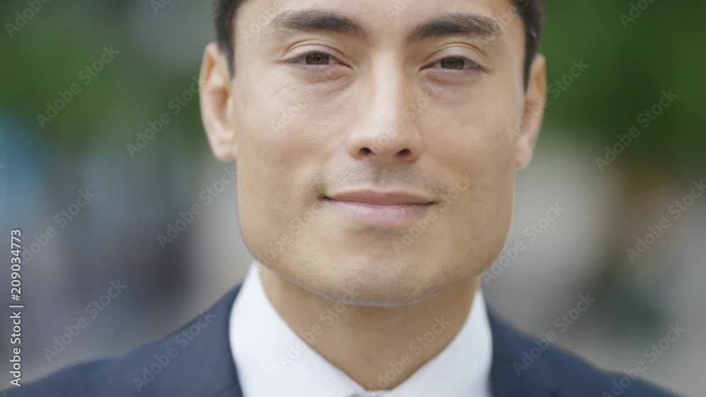 Portrait of handsome Japanese man in a suit smiling to camera Portrait of handsome Japanese man in a suit smiling to camera