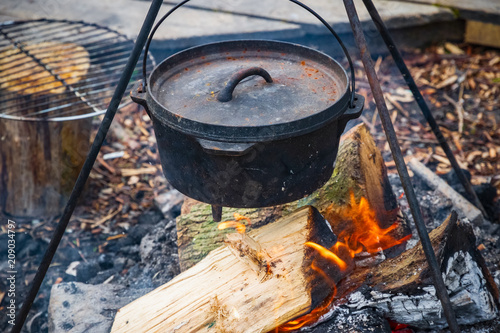 Cooking food in a cauldron over campfire in England