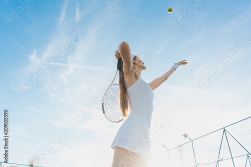 Woman serving the ball for a game of tennis on court