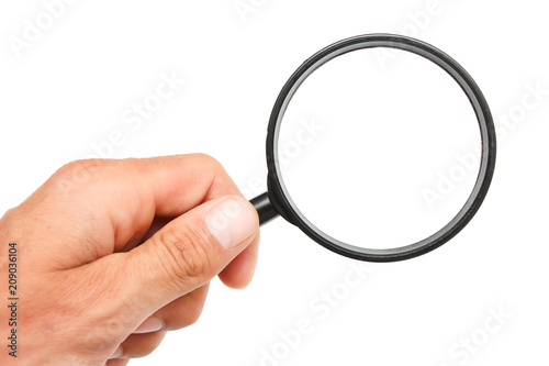 Man's hand with magnifying glass.