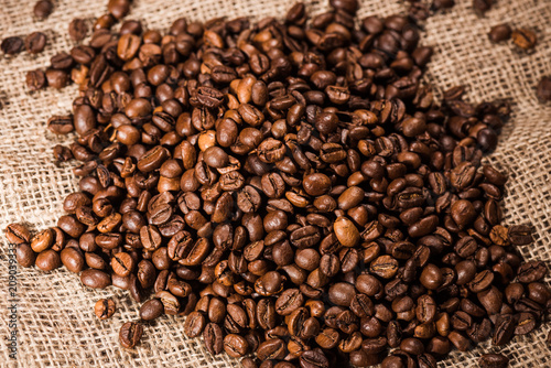 close-up shot of heap of roasted coffee beans on sackcloth