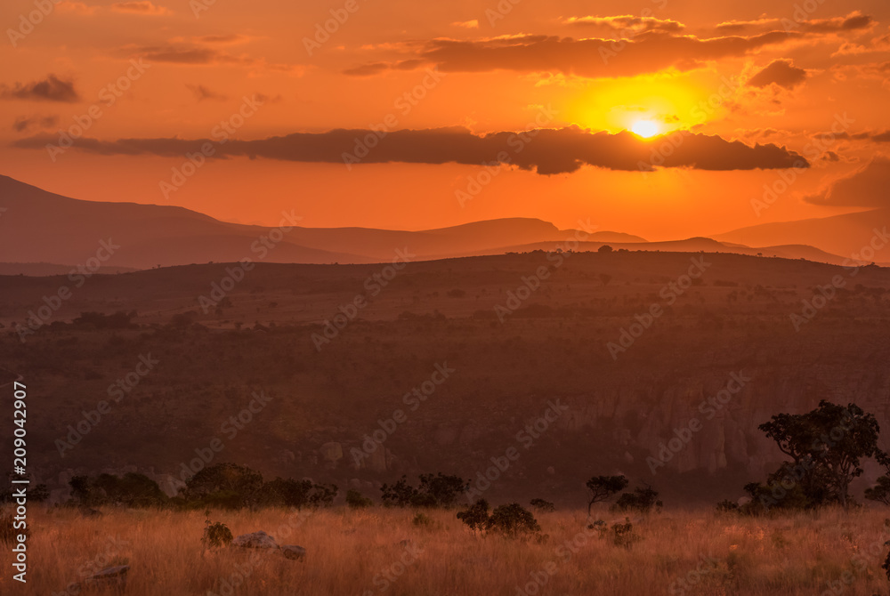 A golden orange sunset over the hills and savannah at Blyde River Canyon in Mpumalanga, South Africa A golden orange sunset over the hills and savannah at Blyde River Canyon in Mpumalanga, South Africa