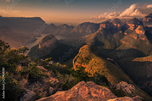 Wide high-angle view of the Three Rondavels and Blyde River Canyon in delicate warm tones at Sunset Golden Hour. Mpumalanga  South Africa