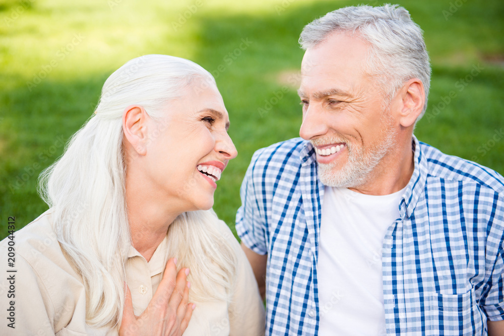 Portrait of cheerful beautiful couple laughing looking at each other having good mood resting outside enjoying time together laughing sincere. Harmony understanding concept Portrait of cheerful beautiful couple laughing looking at each other having good mood resting outside enjoying time together laughing sincere. Harmony understanding concept