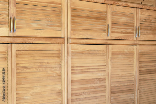 Modern wooden cabinet in classic rustic style. Details of wardrobe case with shutter plank doors. Country house interior