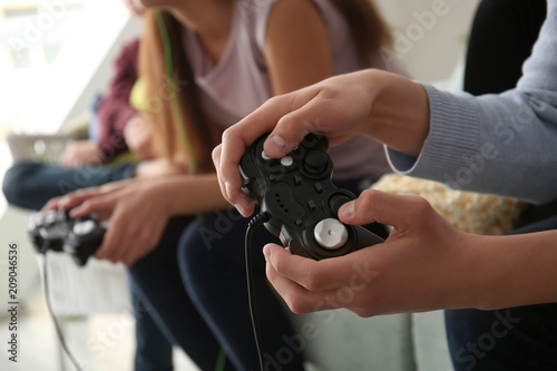 Teenagers playing video games at home  closeup