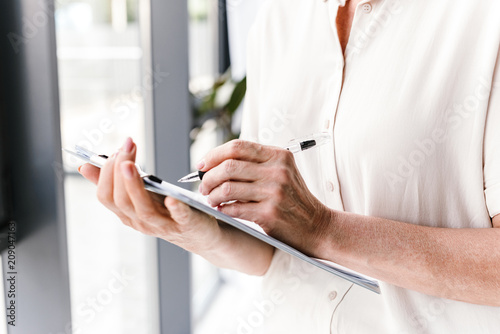 Close up of mature business woman taking notes