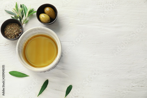 Bowls with oil  olives and spices on white table