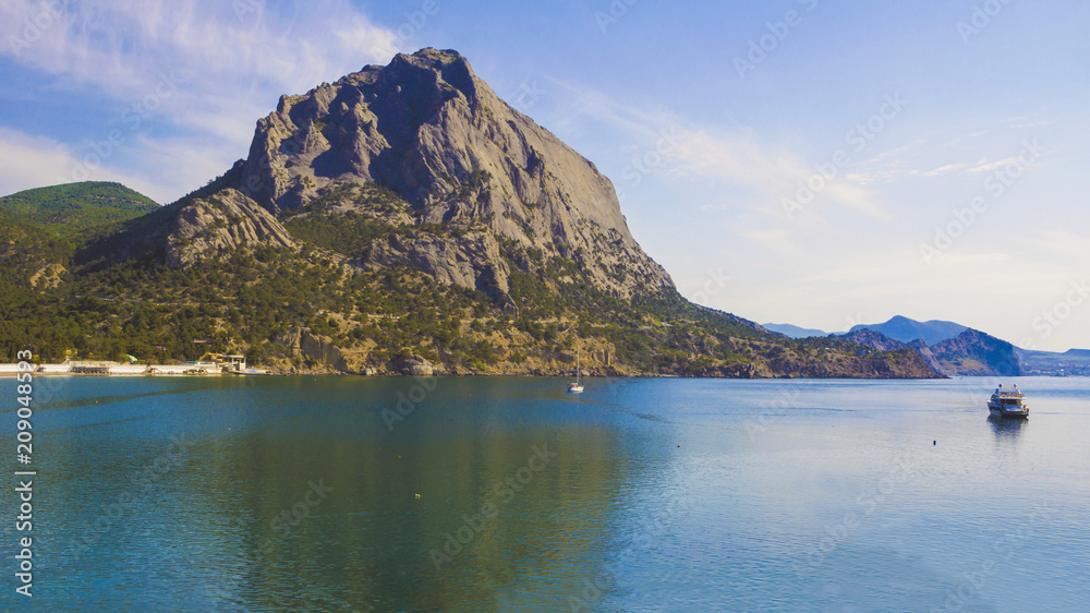 The mountain called Sokol is reflected in the blue waters of the sea Bay.Crimea.