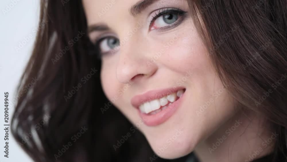 Beauty woman with smiling in studio. Girl face closeup slow motion. Beauty woman with smiling in studio. Girl face closeup slow motion.