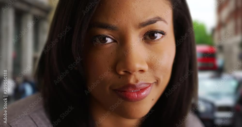 Close up portrait of pretty black woman on London street smiling at camera, Beautiful African American female on urban street in London looking at camera, 4k Close up portrait of pretty black woman on London street smiling at camera, Beautiful African American female on urban street in London looking at camera, 4k