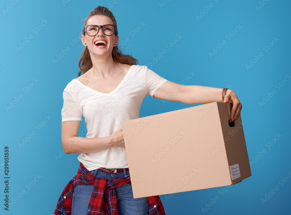 hipster with cardboard box looking up at copy space on blue hipster with cardboard box looking up at copy space on blue