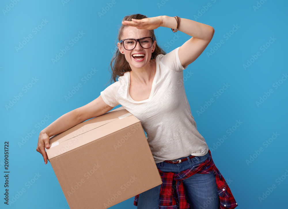 hipster with cardboard box looking into distance on blue hipster with cardboard box looking into distance on blue