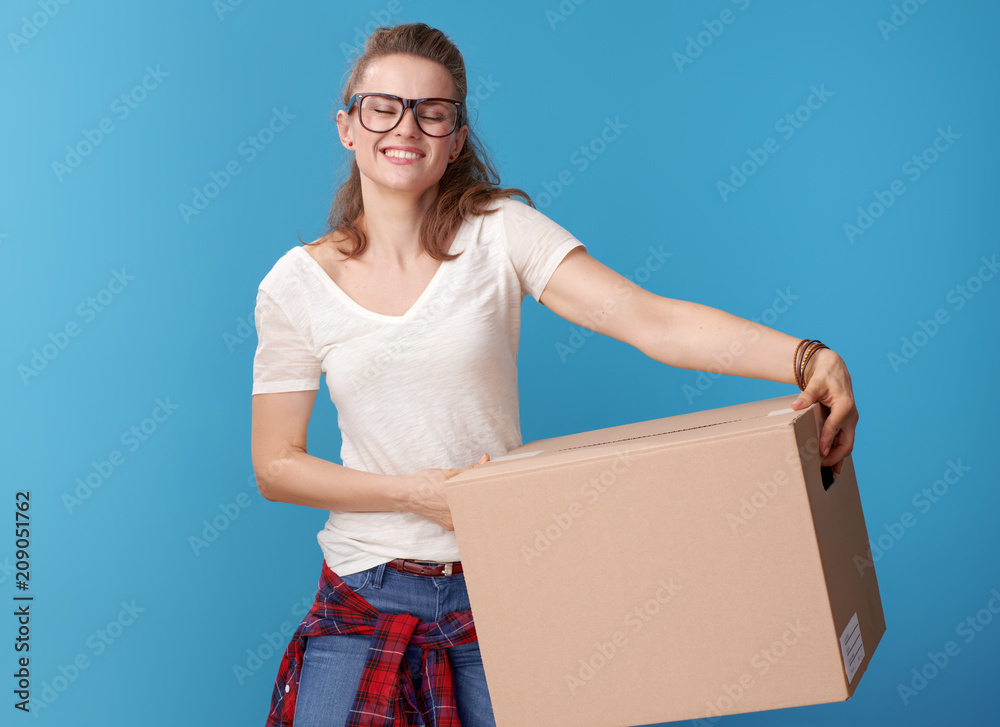 happy modern woman in white shirt with cardboard box on blue happy modern woman in white shirt with cardboard box on blue