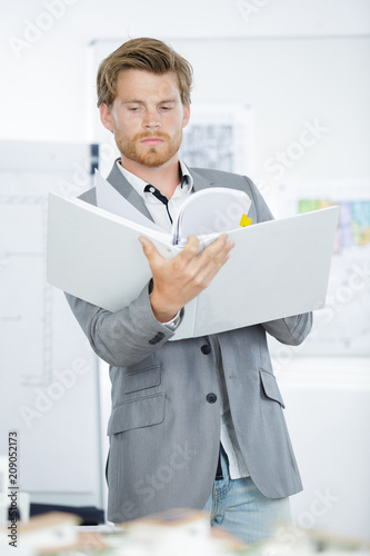 young handsome businessman in suit holding folders