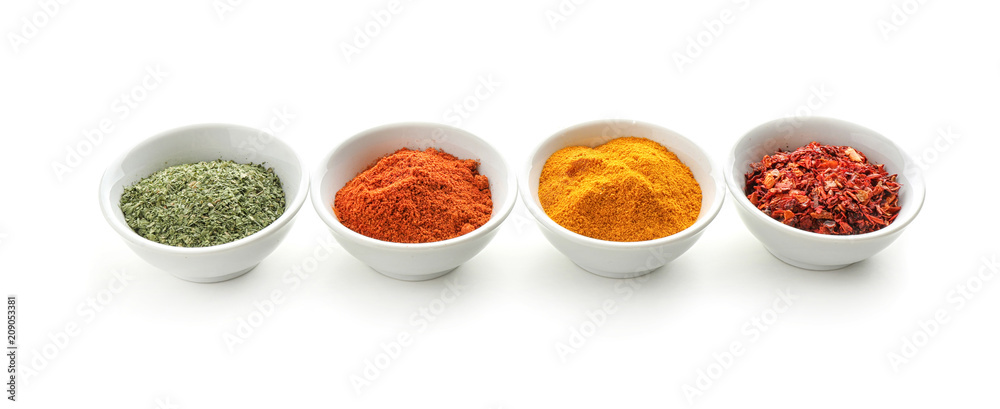 Bowls with various spices on white background