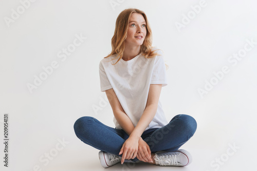 Beautiful young cute redhead woman sitting isolated