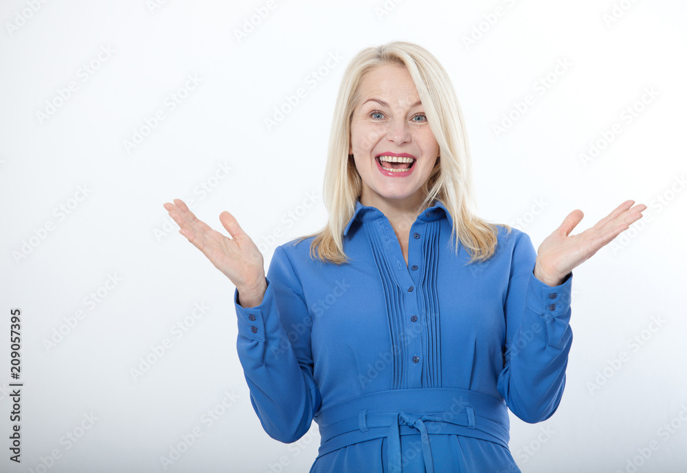 Portrait of happy middle aged woman. Surprised happy woman looking with her mouth open and holding her arms out in excitement. Isolated over white background