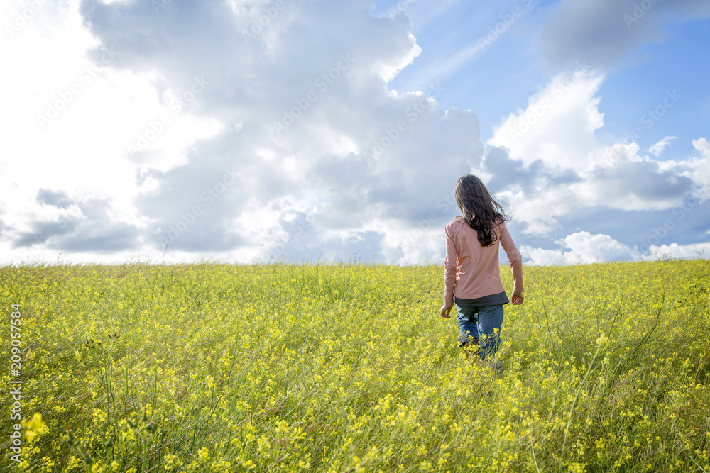 happy girl in a yellow flower field with a dandelion in her hand happy girl in a yellow flower field with a dandelion in her hand
