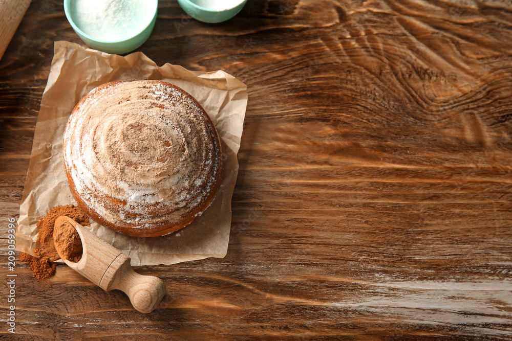 Sweet cinnamon bun on wooden table Sweet cinnamon bun on wooden table