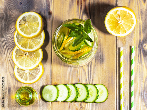 Lemonade with cucumber, lemon and mint on a wooden background.