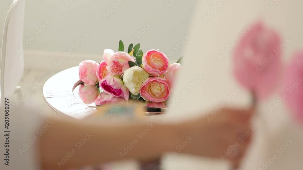 Close-up view of the flowers of the peonies that the girl draws, in the foreground the artist's blurred hand. Flowers in focus. Close-up view of the flowers of the peonies that the girl draws, in the foreground the artist's blurred hand. Flowers in focus.