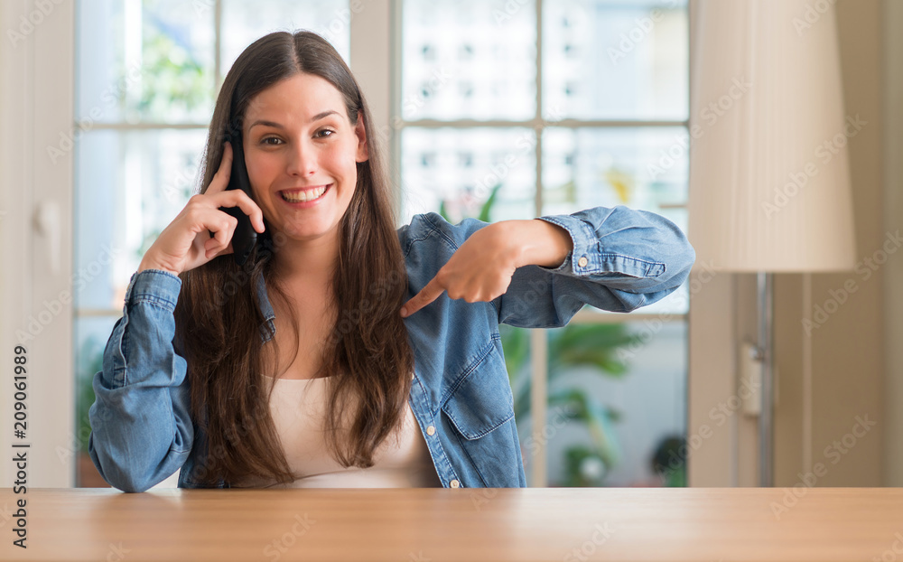 Young woman using smartphone with surprise face pointing finger to himself Young woman using smartphone with surprise face pointing finger to himself