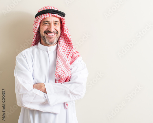 Senior arabic man with a happy face standing and smiling with a confident smile showing teeth