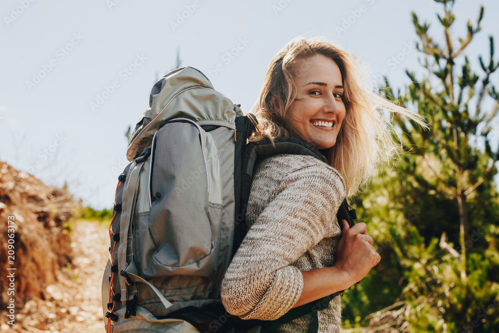 Woman with backpack hiking in nature - obrazy, fototapety, plakaty 