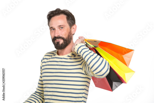 handsome man with colorful paper bags isolated on white. Man in navy slip-over carrying shopping bags. Smiling happy man holding shopping paper bags. Christmas and holidays concept