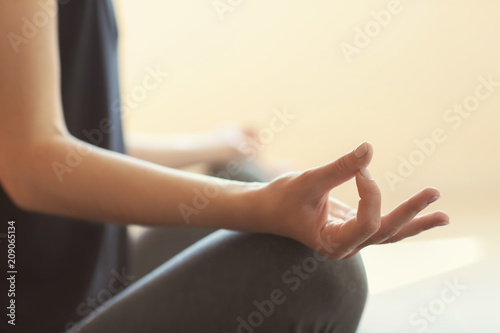 Young woman practicing yoga on light background