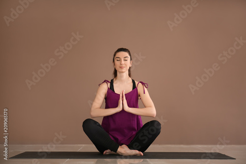 Young woman practicing yoga...