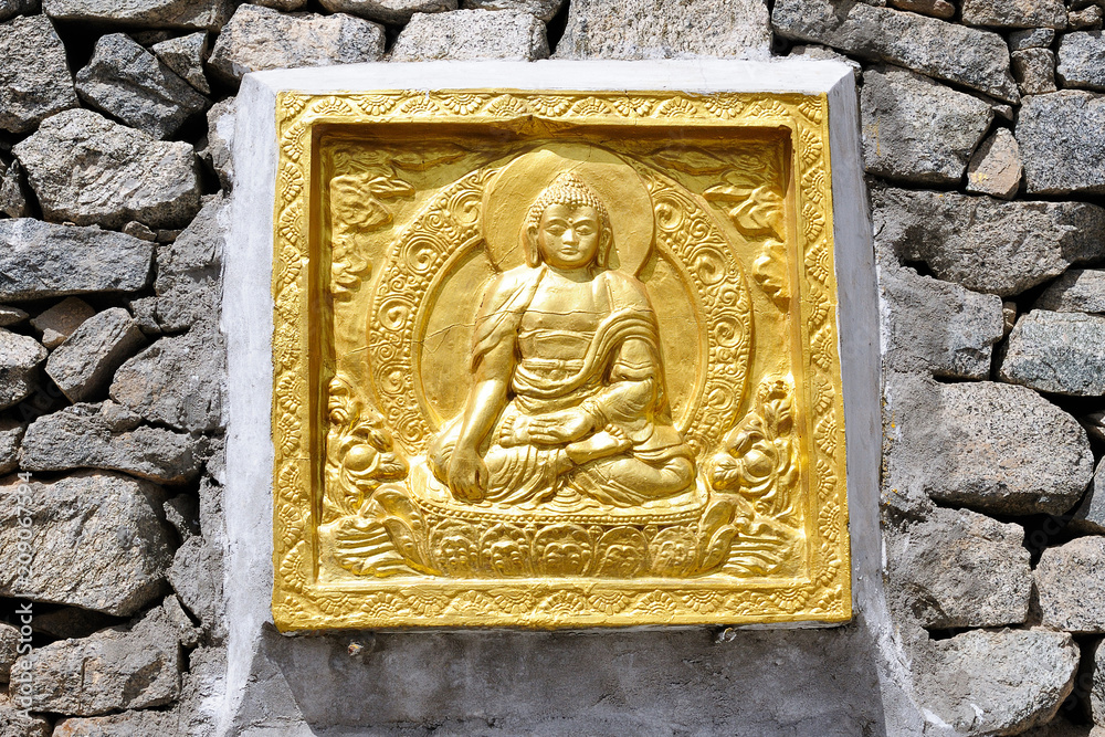 View on Buddha's golden low relief in the lotus position, Leh, district Ladakh - India View on Buddha's golden low relief in the lotus position, Leh, district Ladakh - India