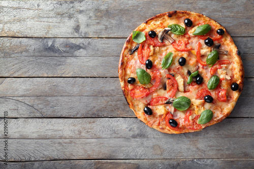 Tasty Italian pizza with olives on wooden background