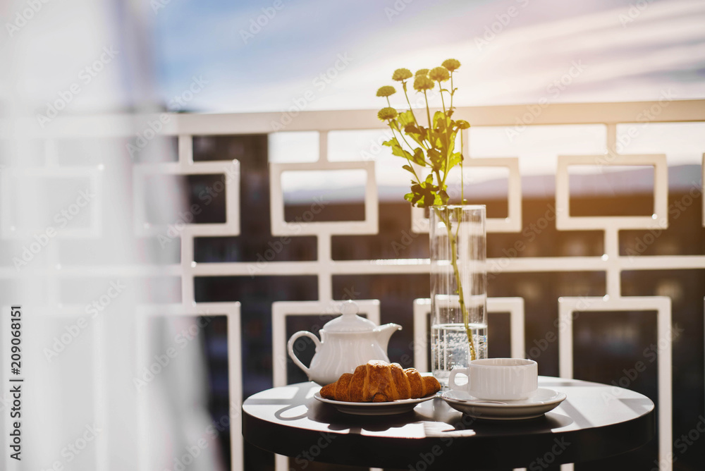Sweet croissants and tea at the window indoors the room Sweet croissants and tea at the window indoors the room