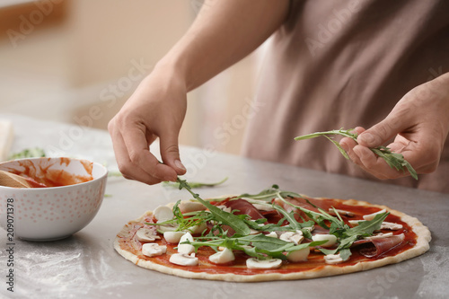 Fototapeta Naklejka Na Ścianę i Meble -  Woman preparing pizza at table in kitchen