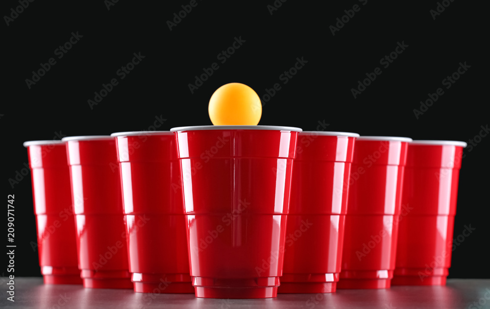 Fototapeta premium Cups and ball for beer pong on table