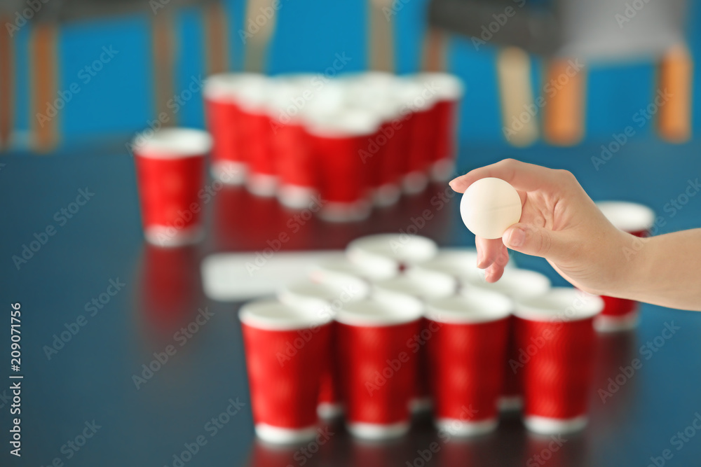 Obraz premium Woman playing beer pong in bar