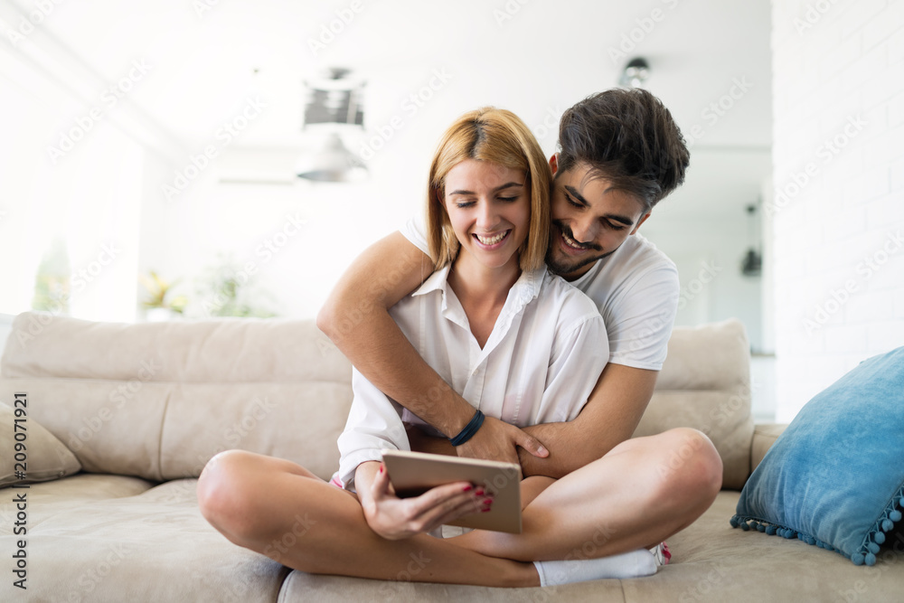 Happy couple surfing on tablet at home Happy couple surfing on tablet at home