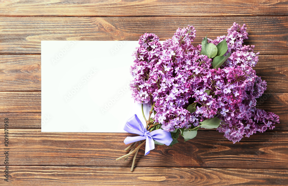 Composition with blank card and blossoming lilac on wooden background Composition with blank card and blossoming lilac on wooden background