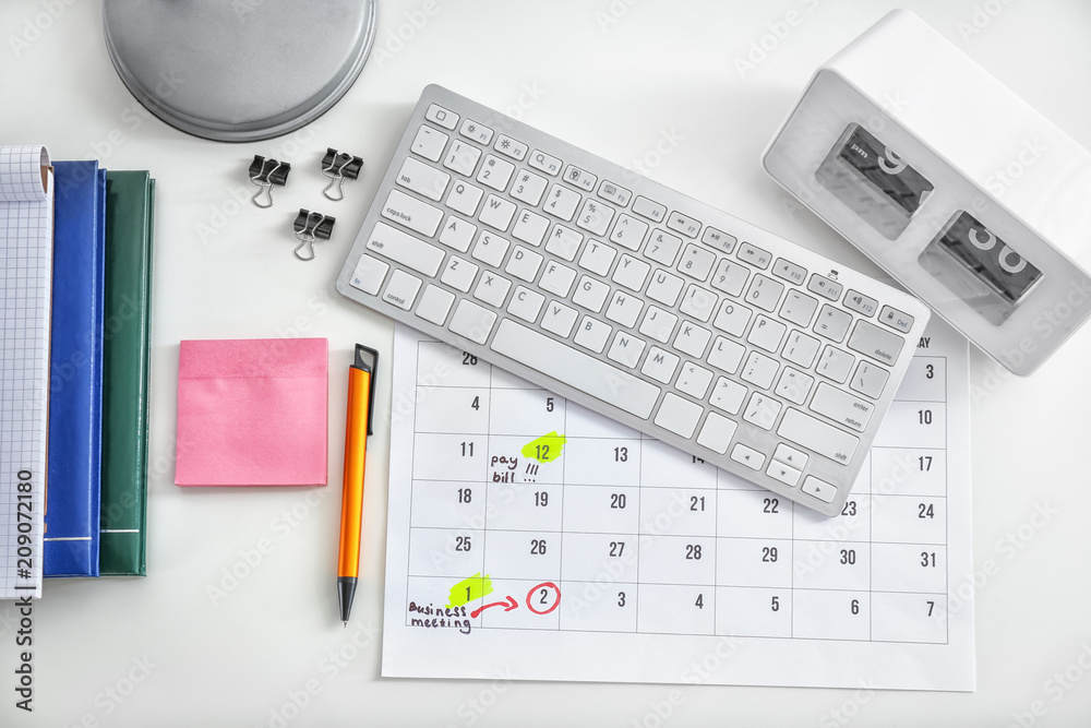 Calendar with notes, computer keyboard and stationery on white background Calendar with notes, computer keyboard and stationery on white background